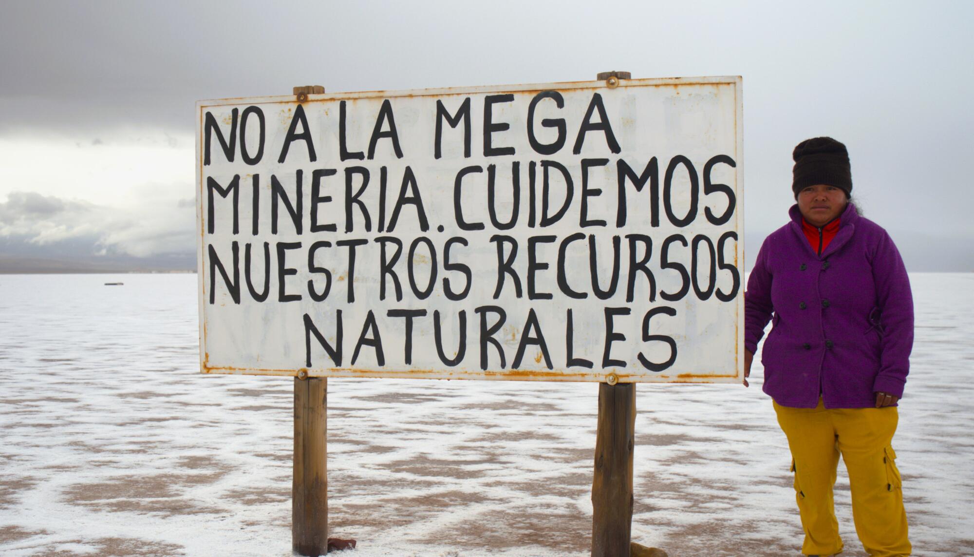 Comunario frente a un cartel contra la minería del litio.
